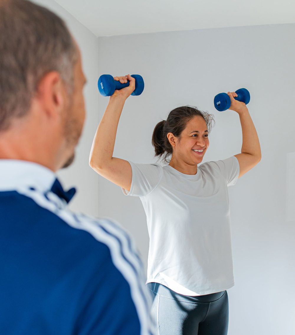 Client lifting weights with PT